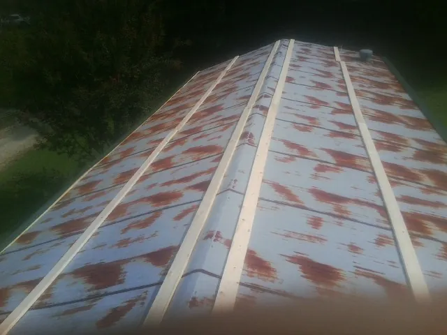 Rusted metal roof panels with new wood purlins before replacement — Storm Damage Roof Repair in Lothian by Roofing Brothers