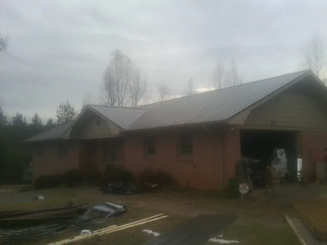 Gray metal roof on a stucco house with an attached garage in Lothian