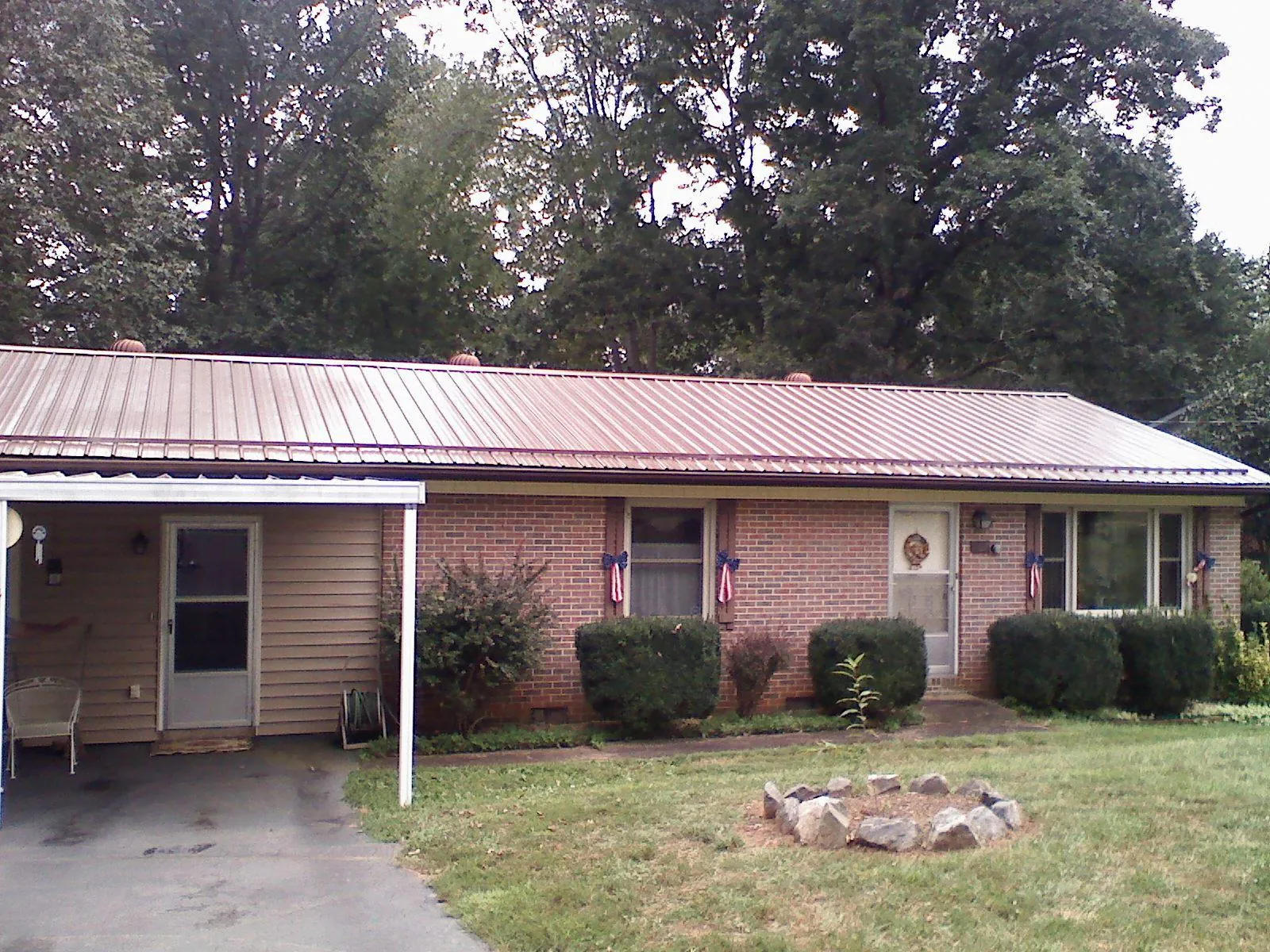 Bronze metal roof and carport on a brick ranch home — Roof Repair work by our crew in Lothian