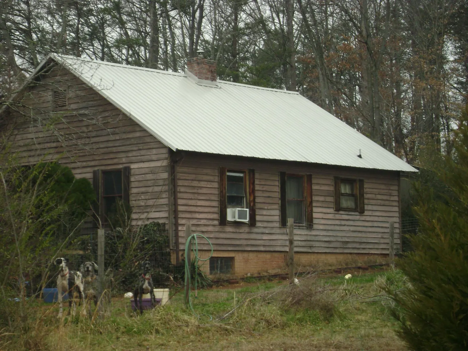 White metal roof on an old wood sided farmhouse, from a Metal Roof Installation job in Lothian